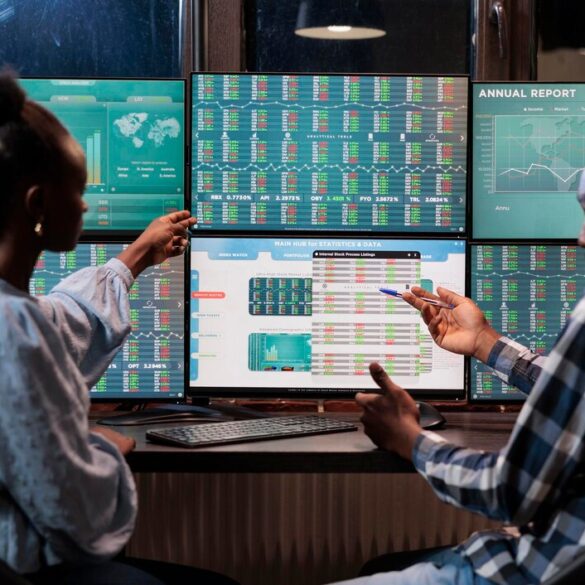 african-american-financial-advisors-reviewing-real-time-market-data-statistics-order-sell-stocks-hedge-fund-traders-sitting-workstation-while-pointing-display-with-live-index-charts_482257-40566